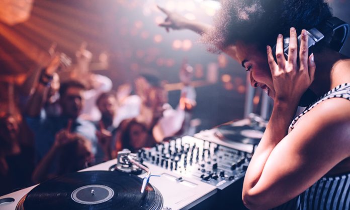 Vinyl Vibes – the next wave Young woman playing music at the club